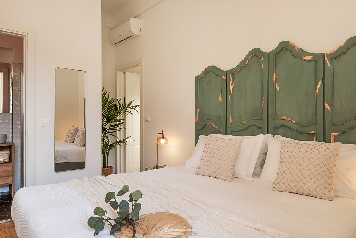 The Bayader Room in Alassio has a bed with a headboard made of old green and bronze doors